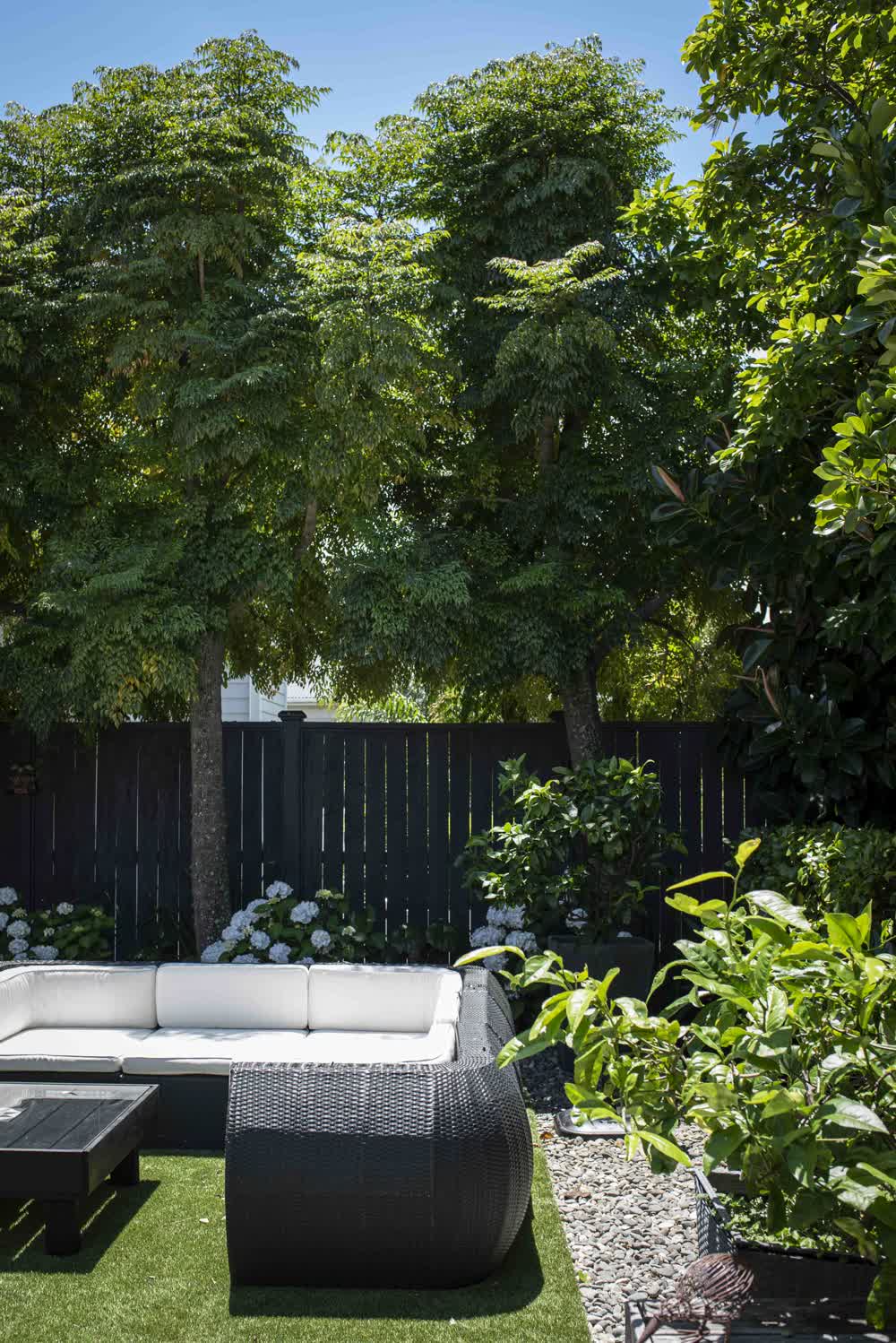 Lush garden design with lawn, hydrangeas, and stone seating area